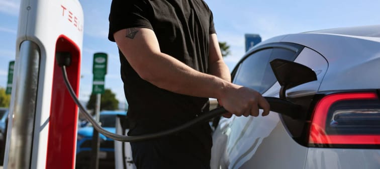 A man charges up his Tesla at a California charging station.