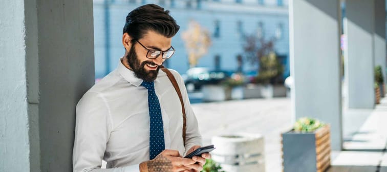 Young businessman carries out its corporate business outside and talking on the phone.