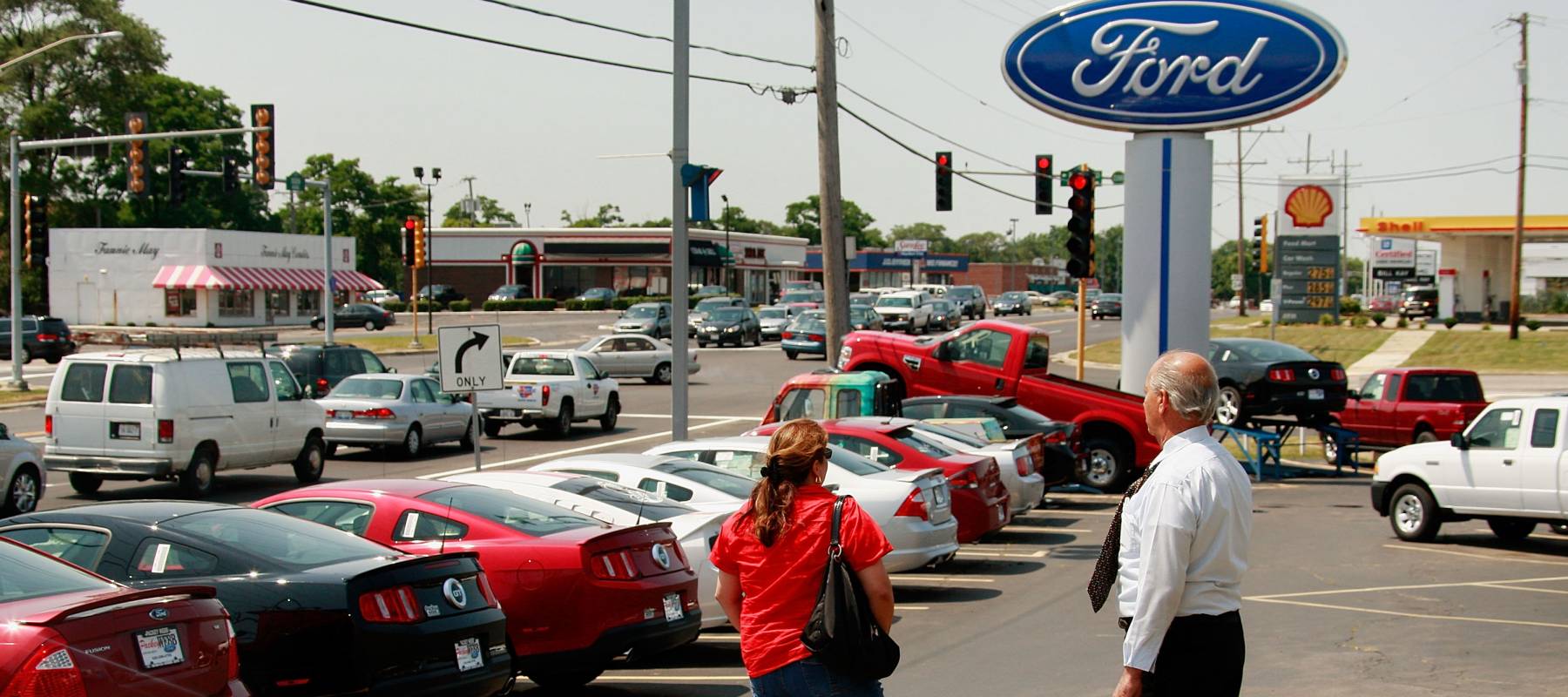 A salesman helps a customer at a Ford dealership.