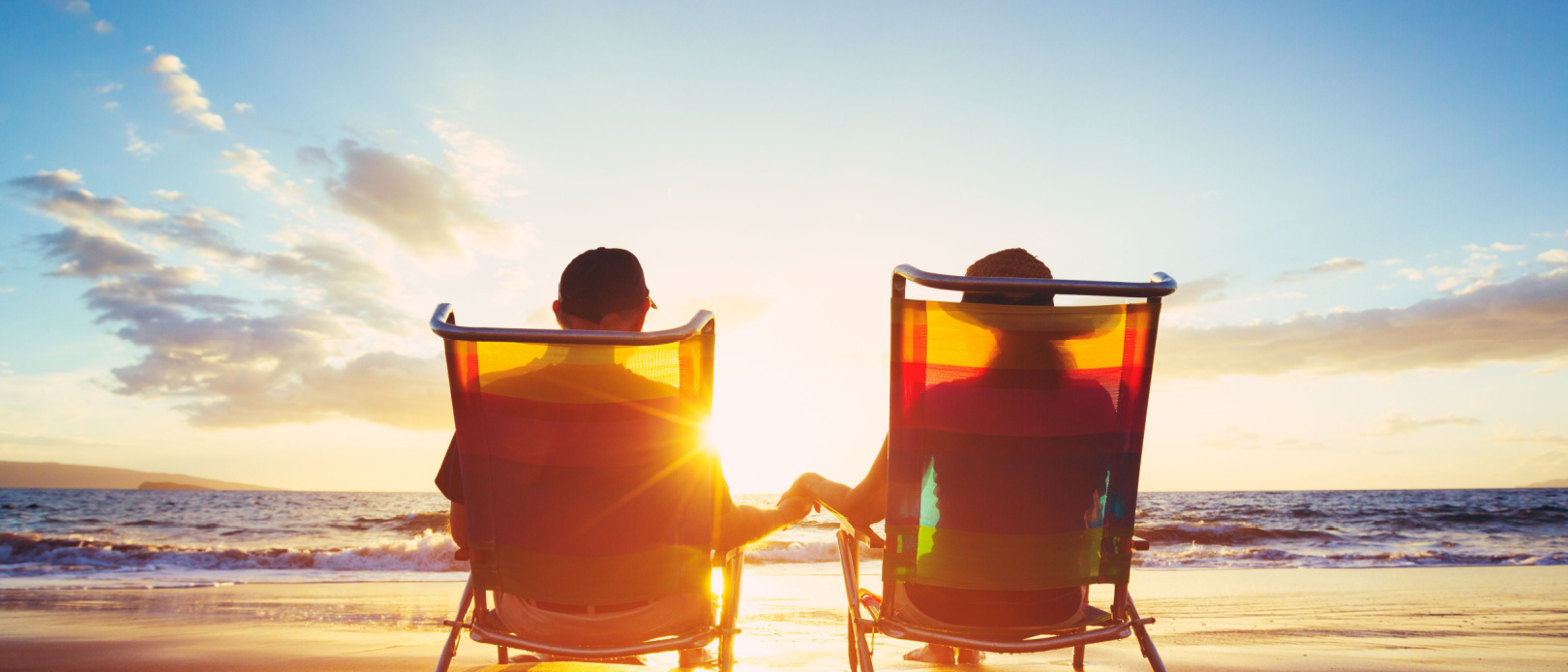 Happy Mature Retired Couple Enjoying Beautiful Sunset at the Beach